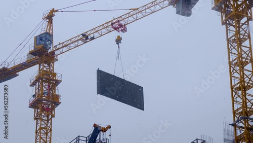 Construction site, where a modern beautiful multi-storey building is being erected by casting a monolith into a formwork reinforced with metal reinforcement. The crane carries the necessary constructi photo