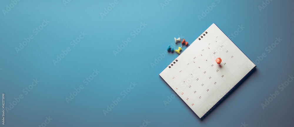 Closeup calendar page with drawing-pins , planning for business meeting or travel planning concept Closeup calendar page with drawing-pins , planning for business meeting or travel planning concept