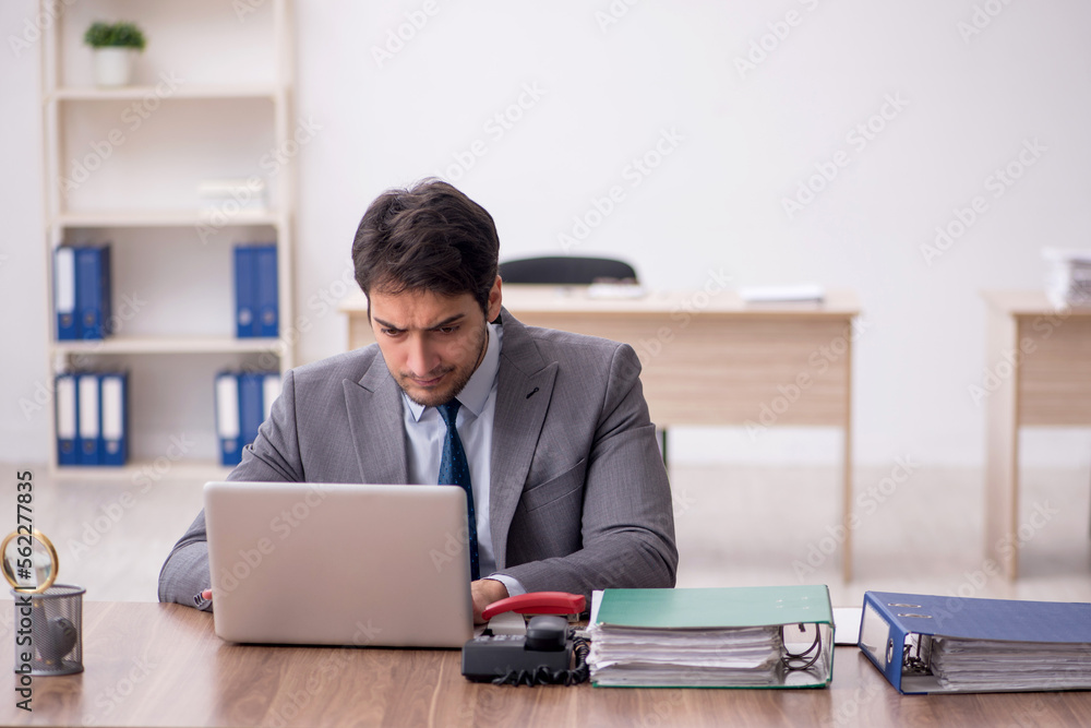 Young male employee working in the office Young male employee working in the office
