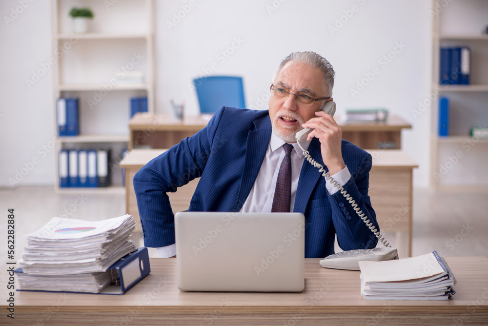 Old male employee working in the office Old male employee working in the office
