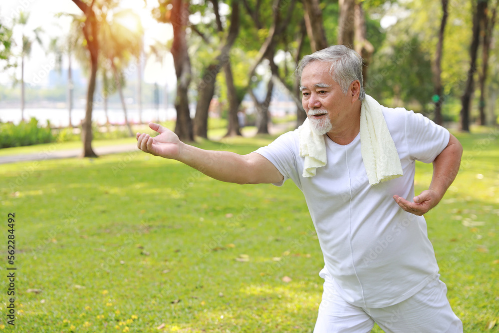 Asian senior man practice yoga excercise, tai chi tranining, stretching and meditation together with relaxation for healthy in park outdoor after retirement. Happy elderly outdoor lifestyle concept Asian senior man practice yoga excercise, tai chi tranining, stretching and meditation together with relaxation for healthy in park outdoor after retirement. Happy elderly outdoor lifestyle concept