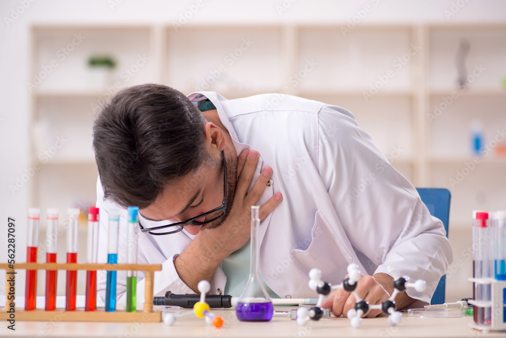 Young male chemist sitting at the lab Young male chemist sitting at the lab