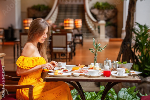 Woman Enjoying breakfast meal in Luxury Restaurant in modern resort or hotel