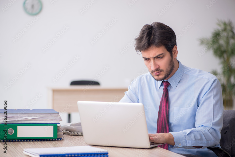 Young male employee sitting in the office Young male employee sitting in the office