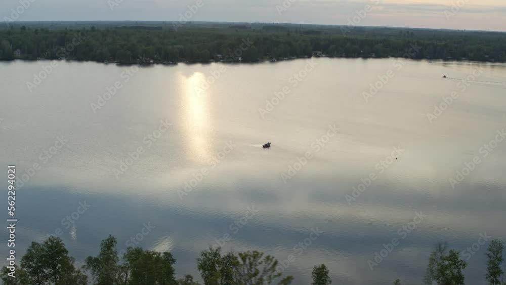 Aerial, small personal fishing boat on a calm lake in the morning Aerial, small personal fishing boat on a calm lake in the morning