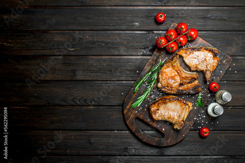 Grilled pork steaks with rosemary and fresh tomatoes.