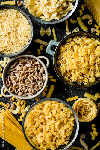 Pasta background. Different types of dry pasta in different bowls.