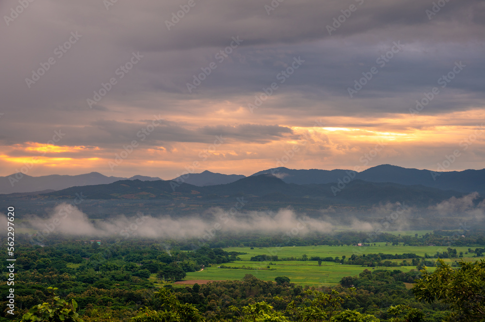 A bird's-eye view of field countryside Surrounded by mountains and nature in the rainy or farming season at Wat Phra That Doi Phra Chan of Lampang Province, Thailand.