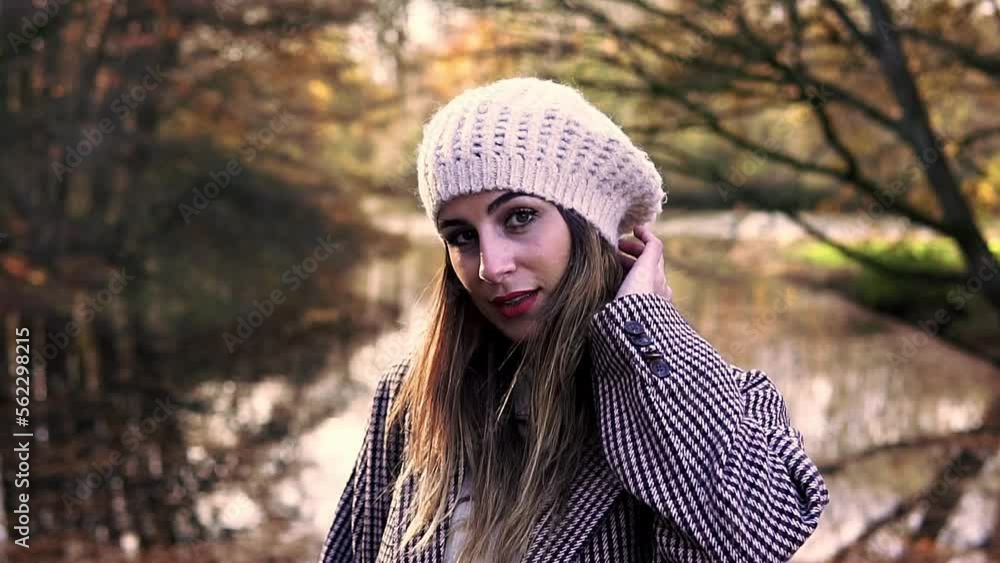 Close-up of a Caucasian woman in an autumn dress looking down and then smiling at the camera in Amsterdam. Close-up of a Caucasian woman in an autumn dress looking down and then smiling at the camera in Amsterdam.