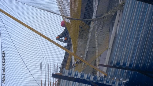Construction site, where a modern beautiful multi-storey building is being erected by casting a monolith into a formwork reinforced with metal reinforcement. The builder makes a hole in the slab photo