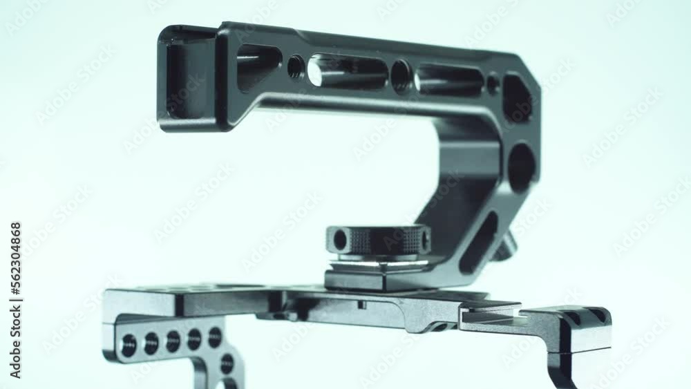 A close up shot of a black metal camera cage with a handler above, video production equipment, on a 360 rotating stand, studio light, slow motion, 4K A close up shot of a black metal camera cage with a handler above, video production equipment, on a 360 rotating stand, studio light, slow motion, 4K