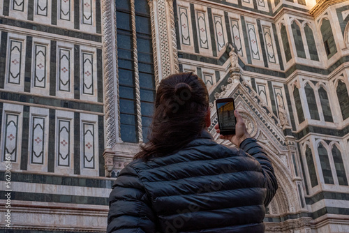 A man taking picture of a church using a mobile phone. Low angle view. 