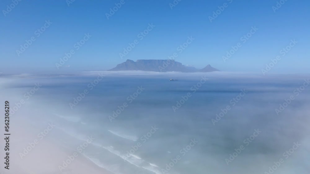 Ship floating in the middle of a foggy ocean and mountains in the background Ship floating in the middle of a foggy ocean and mountains in the background