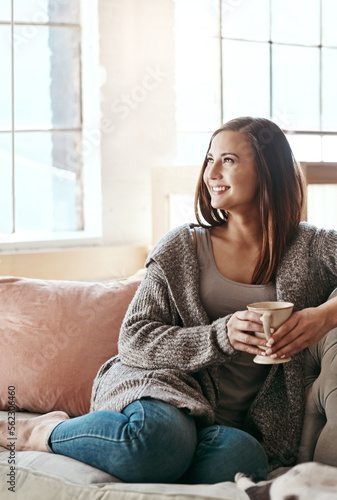 Relax, coffee and woman on a living room couch feeling calm and peace at home. Tea, happiness and smile of a person in the morning thinking with gratitude of peaceful lounge day in a house smiling
