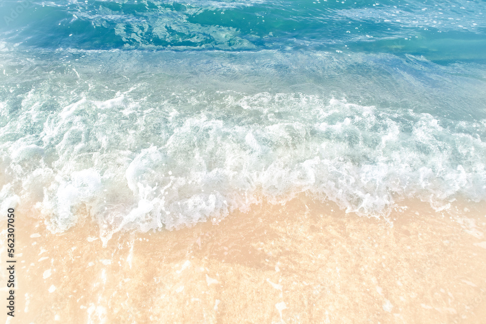 Close-up of the sea wave with the foam surging on the shore. View of sea water in soft focus. Background in a light blur on the theme of a serene summer vacation and relaxed vacation. Close-up of the sea wave with the foam surging on the shore. View of sea water in soft focus. Background in a light blur on the theme of a serene summer vacation and relaxed vacation.