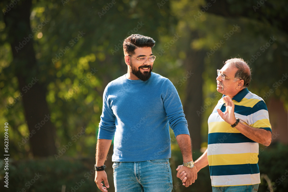 Old indian father talking with his young son at park. Old indian father talking with his young son at park.