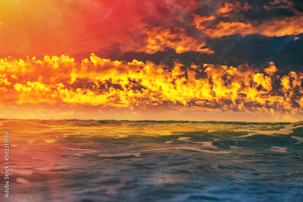 Bright background with sea water close-up in soft focus. Relaxing sunset sea view in orange tones. Dreams of pleasant relaxation by the sea during your holidays. Bright background with sea water close-up in soft focus. Relaxing sunset sea view in orange tones. Dreams of pleasant relaxation by the sea during your holidays.