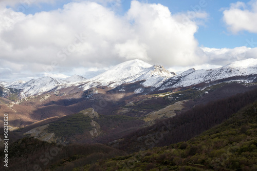  Cadena de montañas con nieve en las cumbres, en paisaje invernal y cielo con nubes