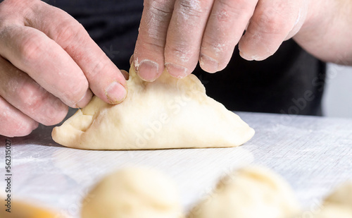 Human hands make pies. The concept of making homemade, tasty and healthy pastries.