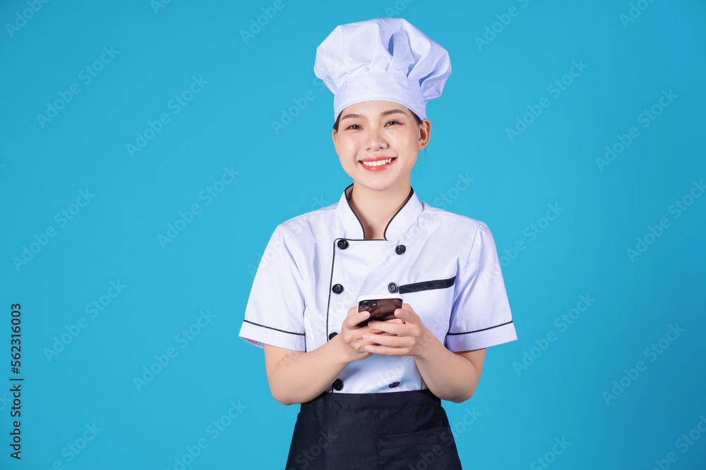 Portrait of young Asian female chef on background Portrait of young Asian female chef on background