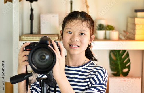 Asian girls having fun and smiling happily learning digital camera photography skills in home studio.