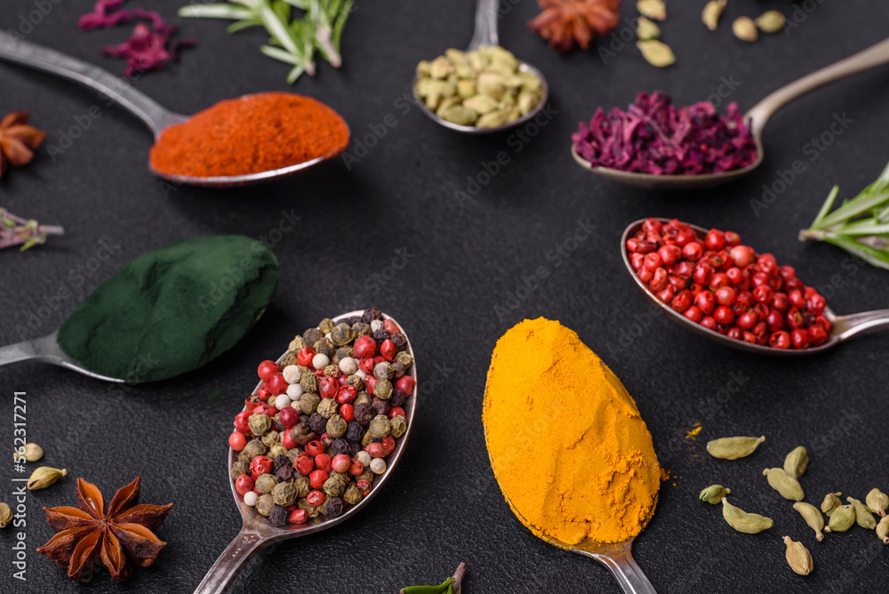 Variation of spices in metal spoons paprika, turmeric, cardamom, a mixture of allspice, thyme and rosemary Variation of spices in metal spoons paprika, turmeric, cardamom, a mixture of allspice, thyme and rosemary