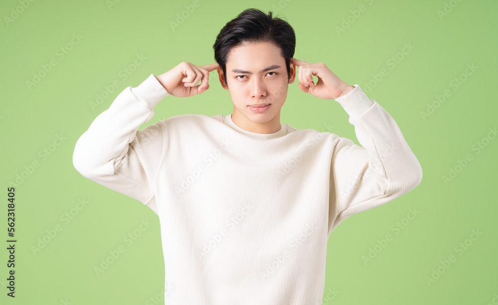 Portrait of young Asian man posing on green background Portrait of young Asian man posing on green background