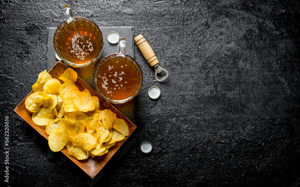 Beer in mugs and chips on a plate. Beer in mugs and chips on a plate.