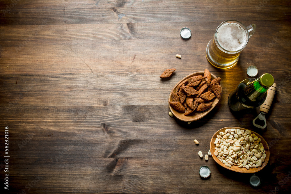 Beer with peanuts and breadcrumbs in the bowls. Beer with peanuts and breadcrumbs in the bowls.