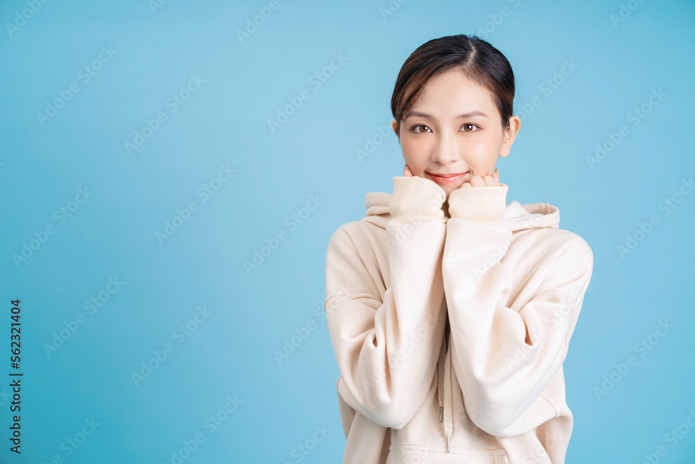 Photo of young Asian girl posing on blue background Photo of young Asian girl posing on blue background