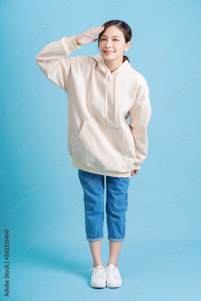 Photo of young Asian girl posing on blue background Photo of young Asian girl posing on blue background