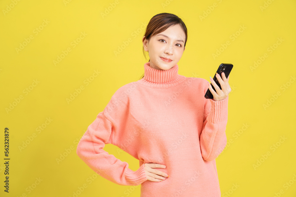 Image of young Asian girl using smartphone on background Image of young Asian girl using smartphone on background