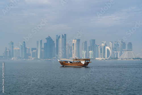 A dhow returns to harbor in Doha, Qatar, with the city's modern skyline in the background.