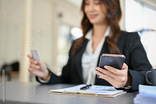 selective focus, Beautiful young Asian businesswoman holding her smartphone and credit card