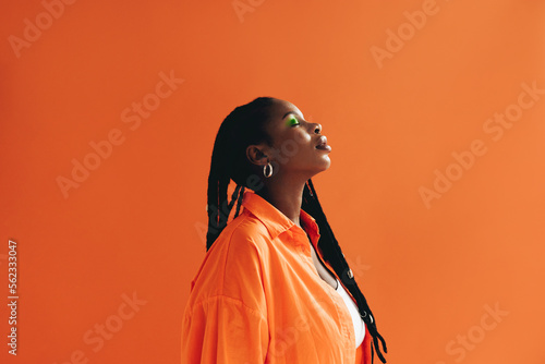 Obraz na plátne Fashionable african woman with dreadlocks standing in a studio with her eyes clo