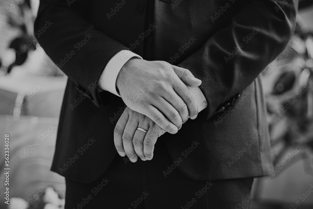 Groom holding hands at the wedding with the ring on the finger