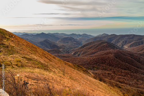 View from a height of 1000 m to the peaks of the Caucasus. Stunning view from the rocky peak of Mount Peus on a sunny day. A magnificent mountain range with high rocky peaks.
