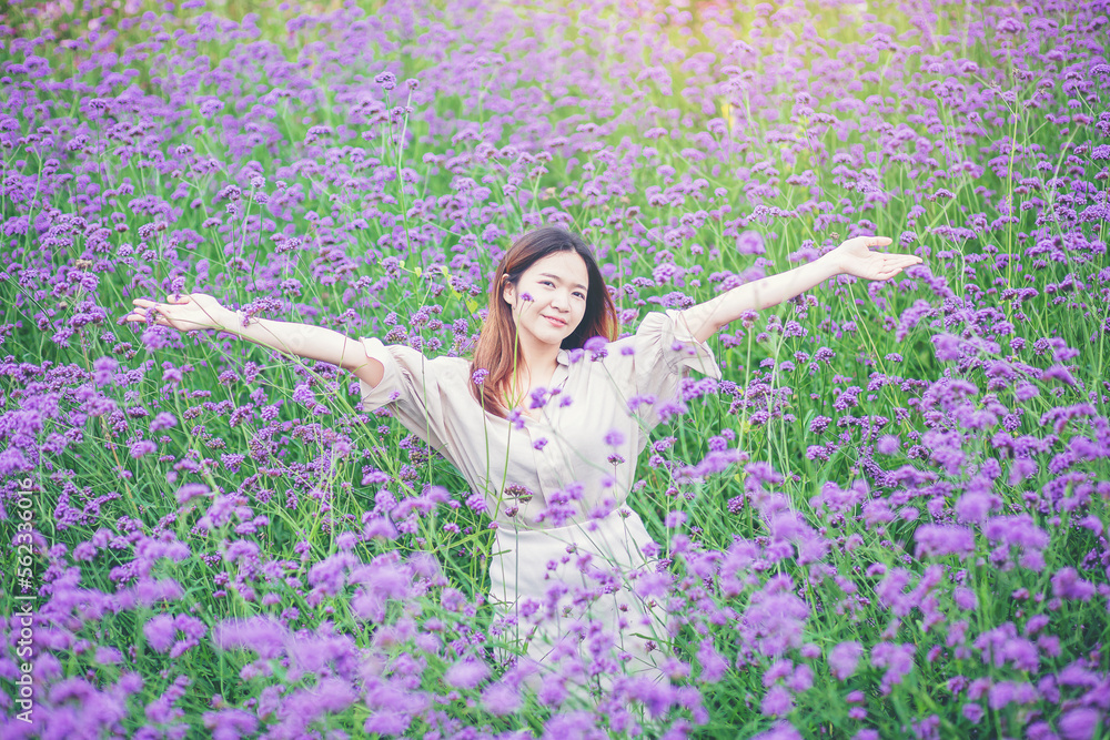 Attractive beautiful woman rise up her arms with happiness freedom in the middle of flower gardens Attractive beautiful woman rise up her arms with happiness freedom in the middle of flower gardens