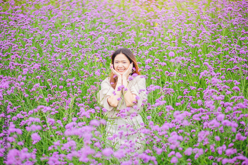 Attractive beautiful woman rise up her arms with happiness freedom in the middle of flower gardens Attractive beautiful woman rise up her arms with happiness freedom in the middle of flower gardens