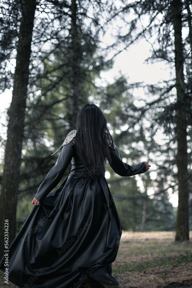 Dark victorian aesthetic scenic photography. Picture of woman goth in black dress with spruce forest on background. High quality wallpaper. Photo concept for ads, travel blog, magazine, article Dark victorian aesthetic scenic photography. Picture of woman goth in black dress with spruce forest on background. High quality wallpaper. Photo concept for ads, travel blog, magazine, article