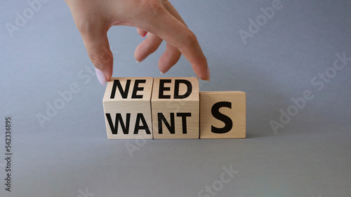 Needs and Wants symbol. Businessman Hand turns cubes and changes word Wants to Needs. Beautiful grey background. Business and Needs and Wants concept. Copy space