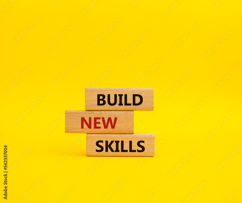 Build New skills symbol. Concept word Build New skills on wooden blocks. Beautiful yellow background. Business and Build New skills concept. Copy space Build New skills symbol. Concept word Build New skills on wooden blocks. Beautiful yellow background. Business and Build New skills concept. Copy space