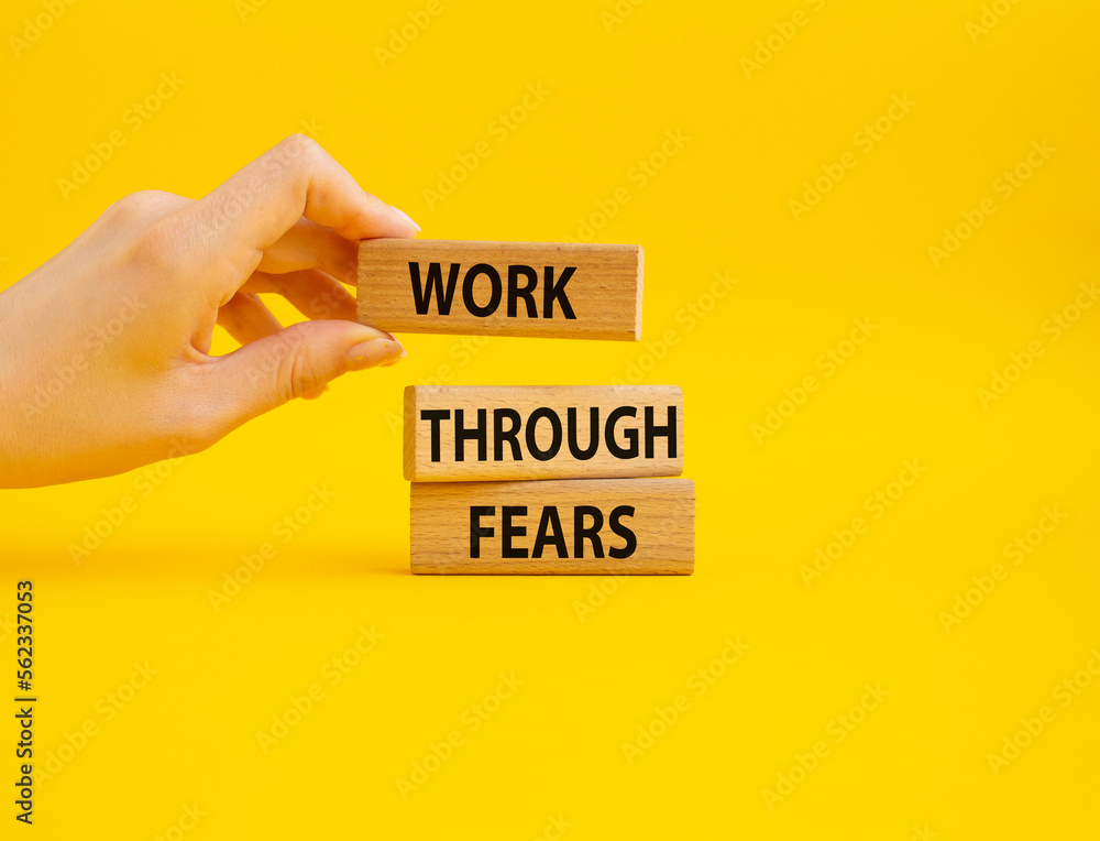 Work through fears symbol. Wooden blocks with words Work through fears. Businessman hand. Beautiful yellow background. Business and Work through fears concept. Copy space. Work through fears symbol. Wooden blocks with words Work through fears. Businessman hand. Beautiful yellow background. Business and Work through fears concept. Copy space.