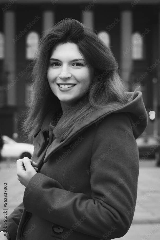 Close up elegant woman in coat on city street monochrome portrait picture. Closeup side view photography with building on background. High quality photo for ads, travel blog, magazine, article