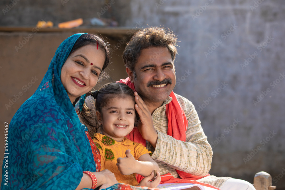 Obraz premium Happy indian farmer couple with little daughter at home.