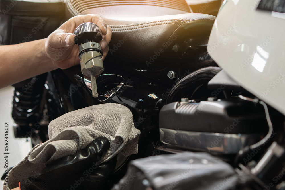 Foto de mechanic check engine oil level with oil dipstick on motorcycle