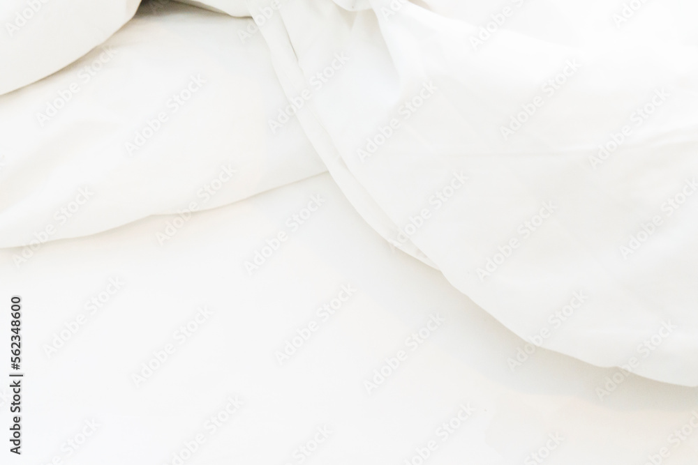 Obraz premium wrinkle messy blanket and white pillow in bedroom after waking up in the morning, from sleeping in a long night, details of duvet and blanket, an unmade bed in hotel bedroom with white blanket