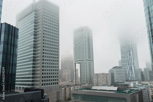 Beautiful modern European city of Warsaw, Poland with office and business buildings with fog on a cloudy day. Urban wallpaper, concept