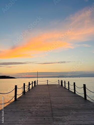 Empty wooden pier at the sea  sunset time  orange and purple clouds