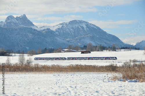 A train is going through the snowy landscape in the Alps